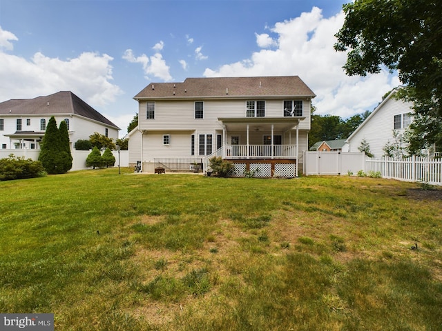 back of house with a wooden deck and a lawn