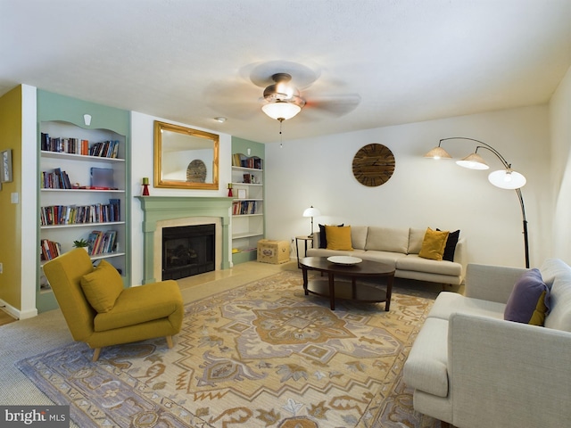 carpeted living room featuring built in shelves and ceiling fan