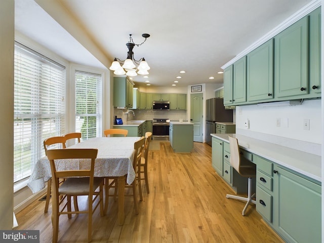 dining area featuring a wealth of natural light, sink, and light hardwood / wood-style floors