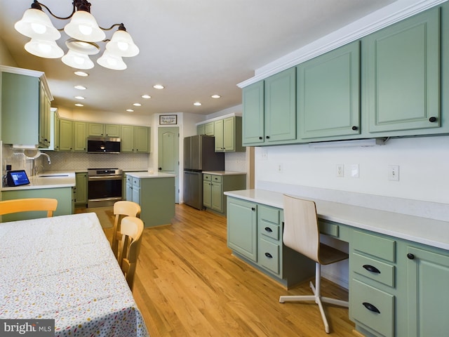 kitchen with a center island, stainless steel appliances, hanging light fixtures, and green cabinetry