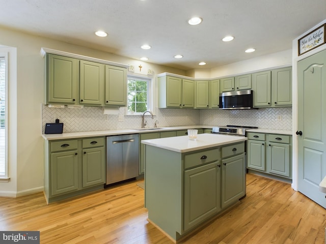 kitchen with a center island, green cabinets, sink, and appliances with stainless steel finishes