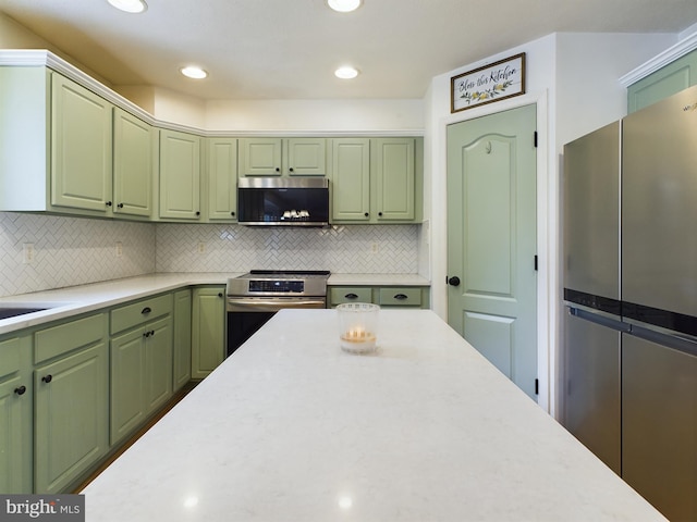 kitchen with tasteful backsplash, stainless steel appliances, and green cabinetry