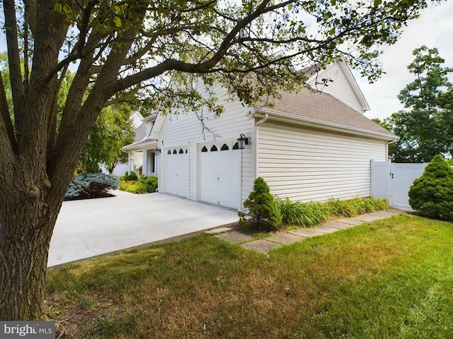 view of side of property with a lawn and a garage