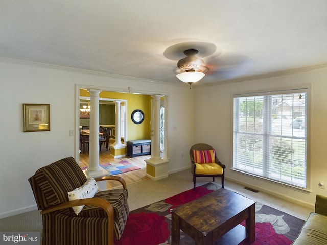 carpeted living room featuring ornate columns and ornamental molding