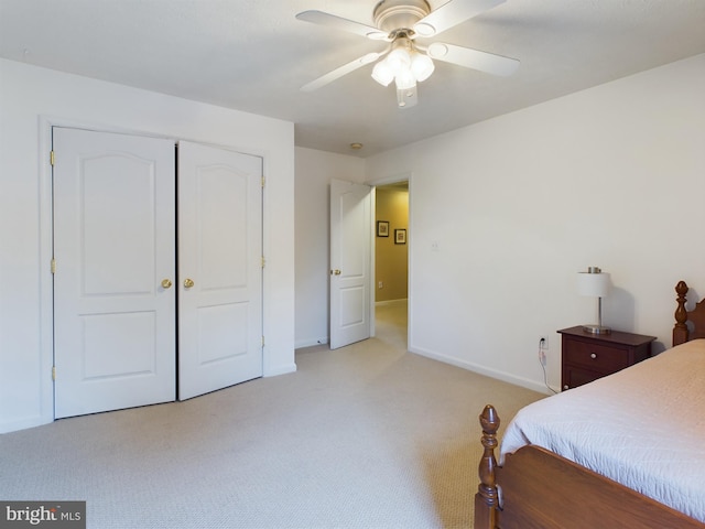 bedroom with ceiling fan, a closet, and light carpet