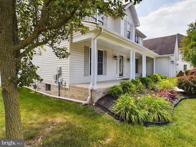 exterior space with covered porch and a front lawn