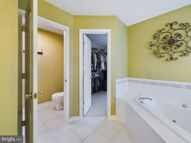 bathroom with tiled bath, tile patterned flooring, and toilet