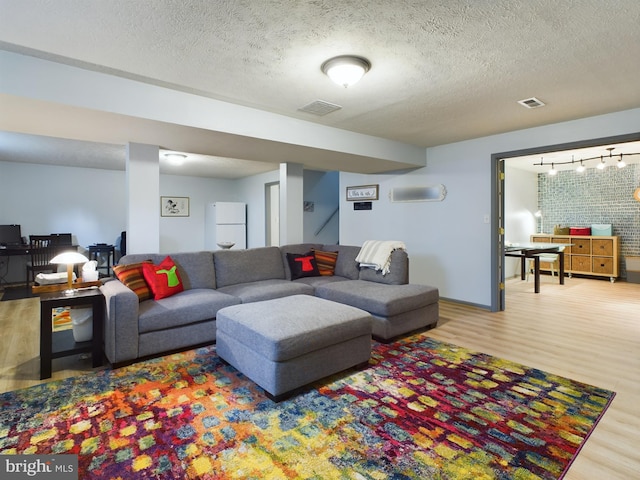 living room with wood-type flooring and a textured ceiling