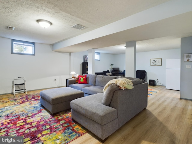 living room featuring light hardwood / wood-style floors and a textured ceiling