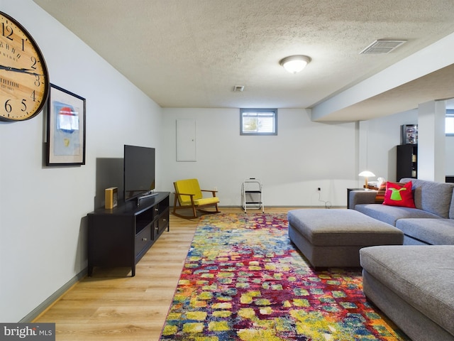 living room featuring electric panel, hardwood / wood-style floors, and a textured ceiling