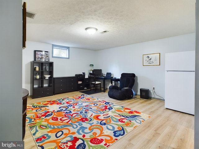 playroom with wood-type flooring and a textured ceiling