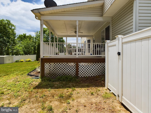 deck featuring ceiling fan and a yard