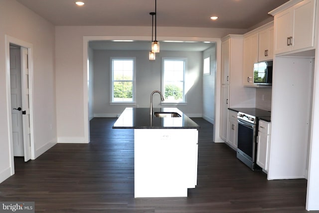 kitchen featuring sink, stainless steel range with electric cooktop, an island with sink, pendant lighting, and white cabinets