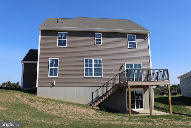 back of house featuring a wooden deck and a lawn