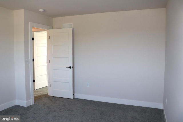 empty room with dark colored carpet