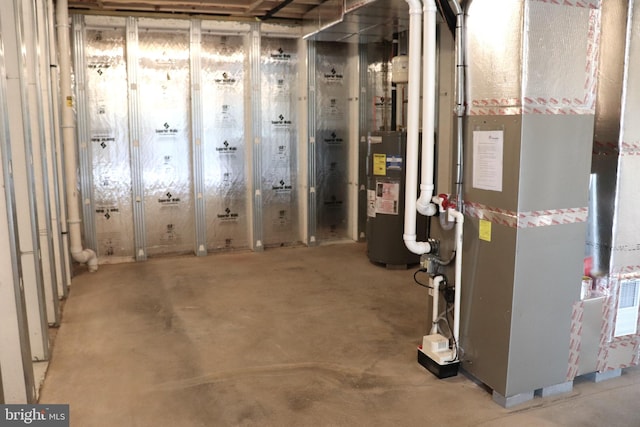 basement featuring heating unit and electric water heater