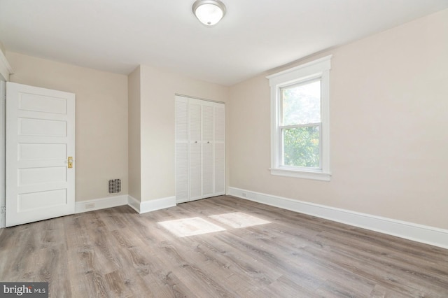 unfurnished bedroom featuring a closet and light hardwood / wood-style flooring