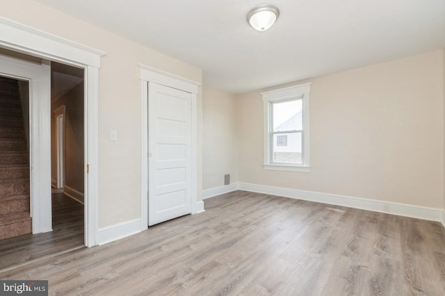 unfurnished bedroom featuring light hardwood / wood-style flooring and a closet