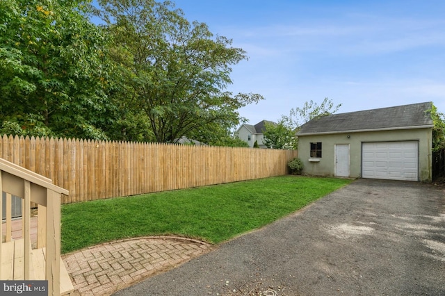 view of yard with a garage and an outbuilding