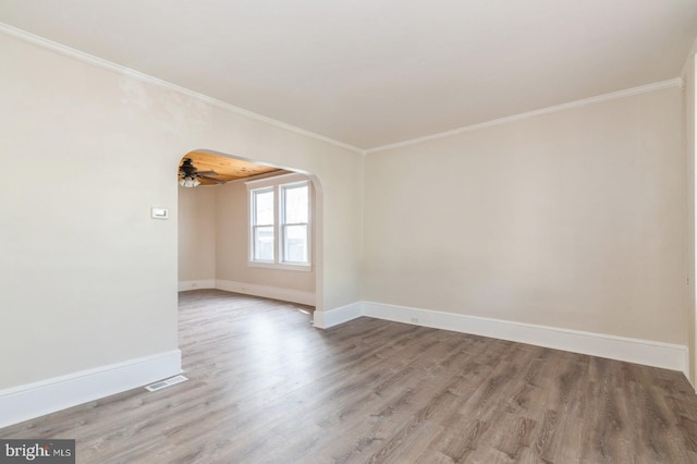 unfurnished room with ceiling fan, light wood-type flooring, and crown molding