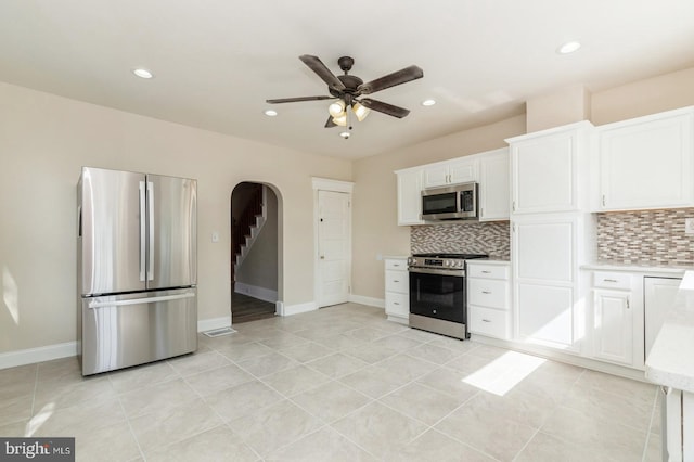 kitchen with white cabinetry, ceiling fan, stainless steel appliances, backsplash, and light tile patterned floors