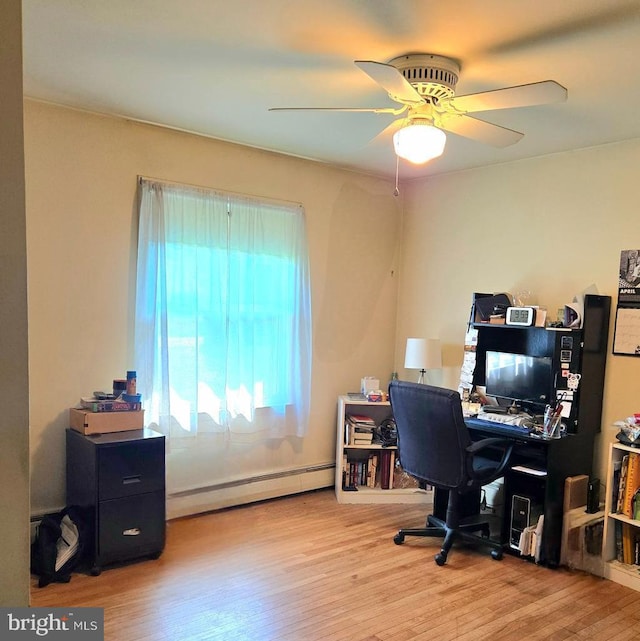 office area with a ceiling fan, a baseboard heating unit, and wood finished floors