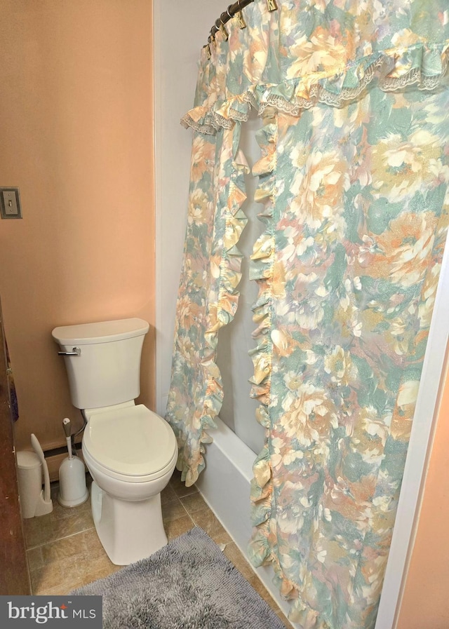 bathroom featuring toilet, tile patterned flooring, and shower / tub combo with curtain