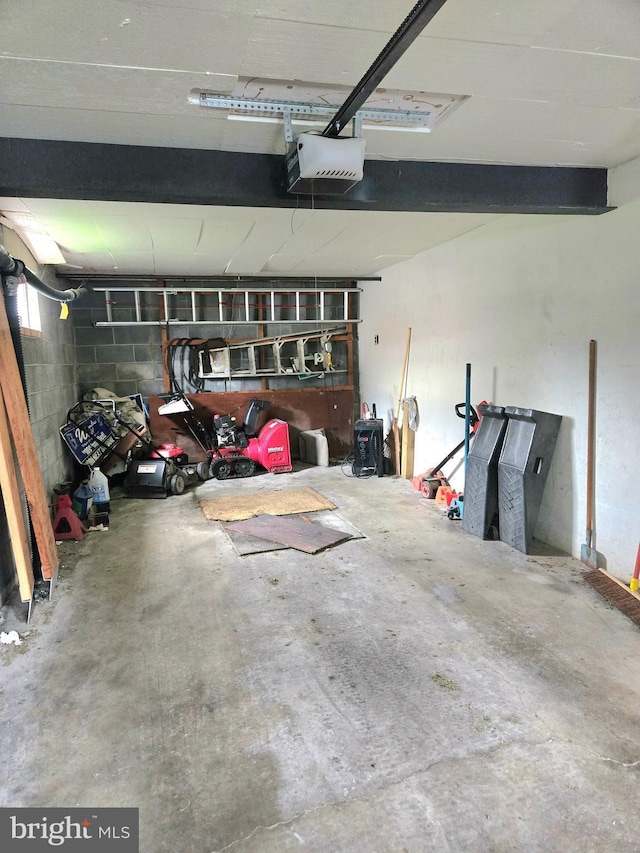 garage with concrete block wall and a garage door opener