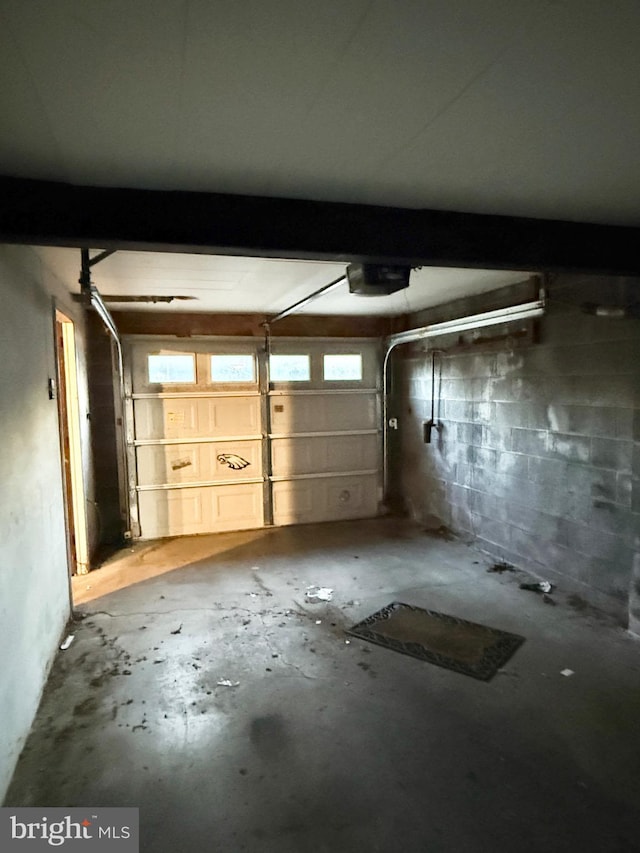 garage with concrete block wall and a garage door opener