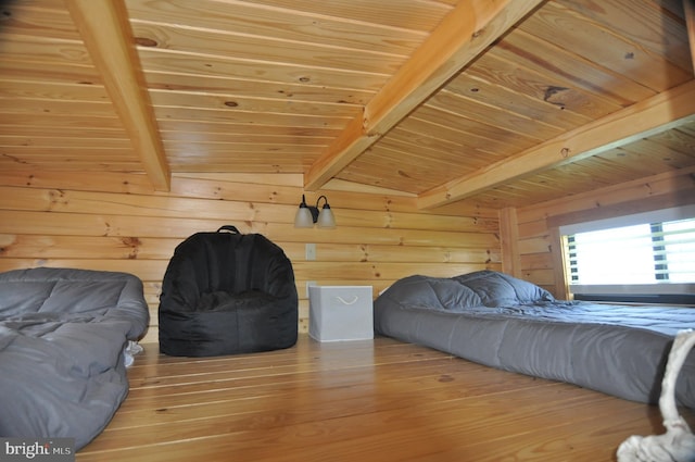 bedroom featuring beamed ceiling, wooden ceiling, wood finished floors, and wooden walls