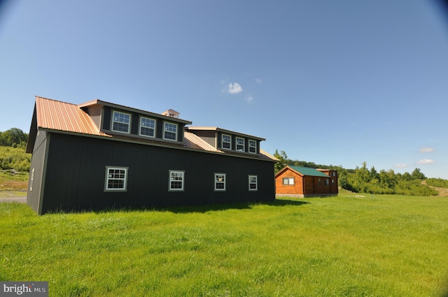 view of side of property with metal roof and a lawn