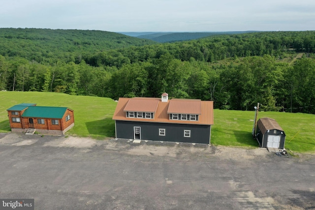 bird's eye view with a wooded view