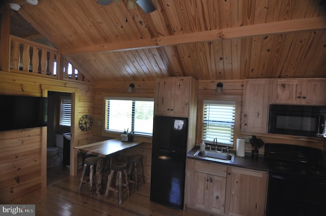 kitchen with dark countertops, a sink, black appliances, and light brown cabinetry