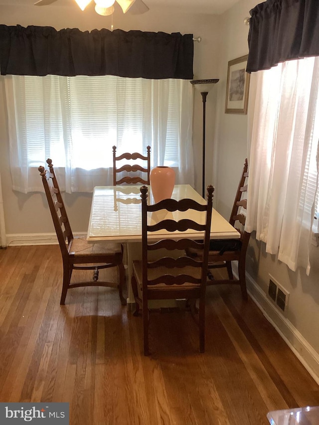 dining space with ceiling fan and wood-type flooring