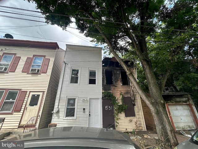 view of front of property featuring a garage and cooling unit