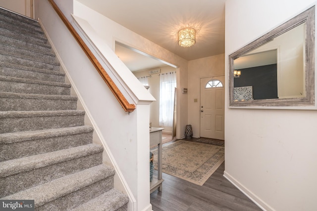 foyer with dark hardwood / wood-style flooring and a chandelier