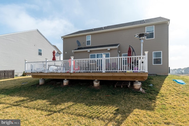 rear view of property with a wooden deck and a yard