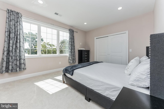 bedroom with light carpet and a closet