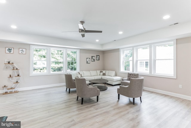 living room featuring ceiling fan, light hardwood / wood-style flooring, and a healthy amount of sunlight