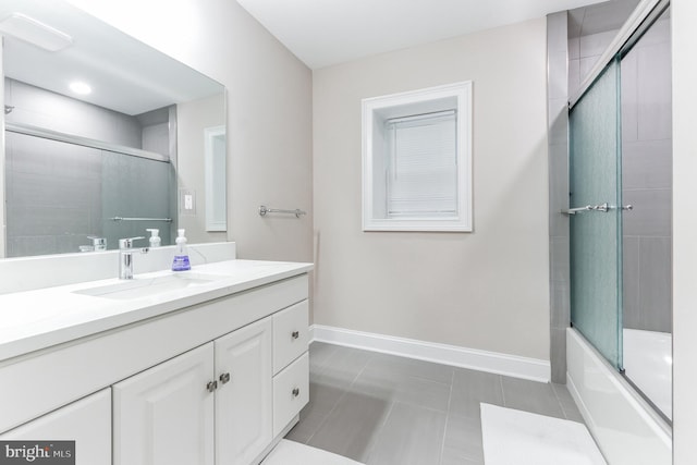 bathroom with combined bath / shower with glass door, vanity, and tile patterned floors