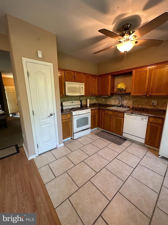 kitchen featuring sink, white appliances, ceiling fan, light tile patterned flooring, and decorative backsplash