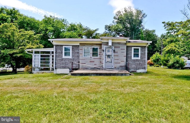 back of property with a lawn and a sunroom