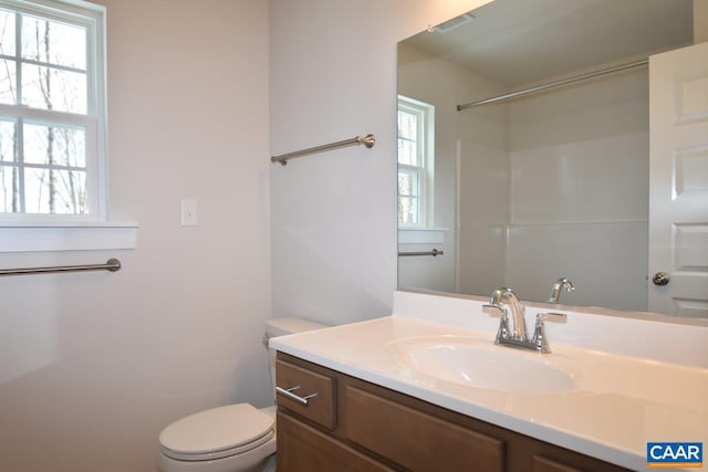 bathroom featuring vanity, a wealth of natural light, and toilet