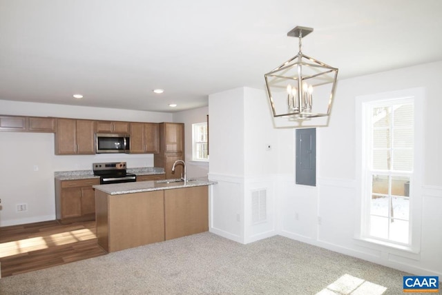 kitchen with pendant lighting, stainless steel appliances, electric panel, a notable chandelier, and light carpet