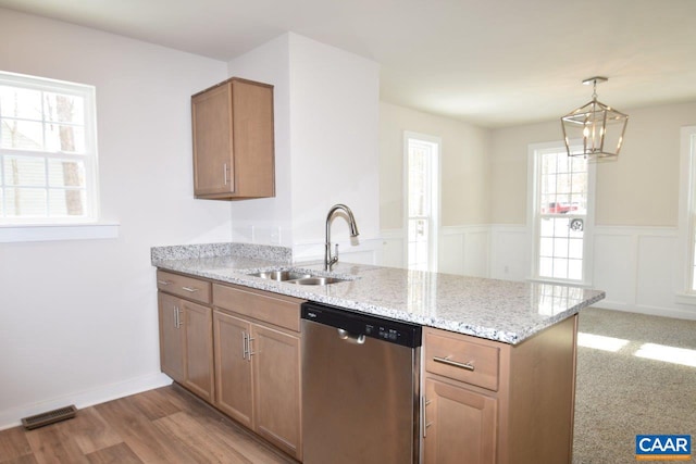 kitchen featuring sink, dishwasher, hanging light fixtures, light stone counters, and a notable chandelier