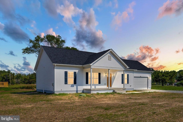 modern inspired farmhouse featuring a lawn, covered porch, and a garage