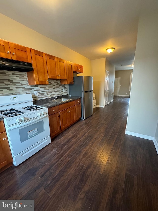 kitchen featuring tasteful backsplash, dark hardwood / wood-style floors, gas range gas stove, sink, and stainless steel fridge