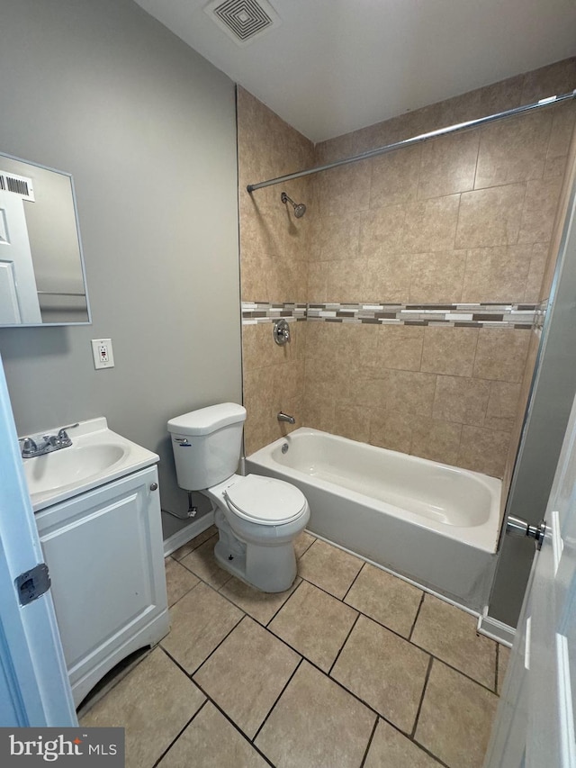 full bathroom with toilet, tile patterned flooring, tiled shower / bath, and vanity