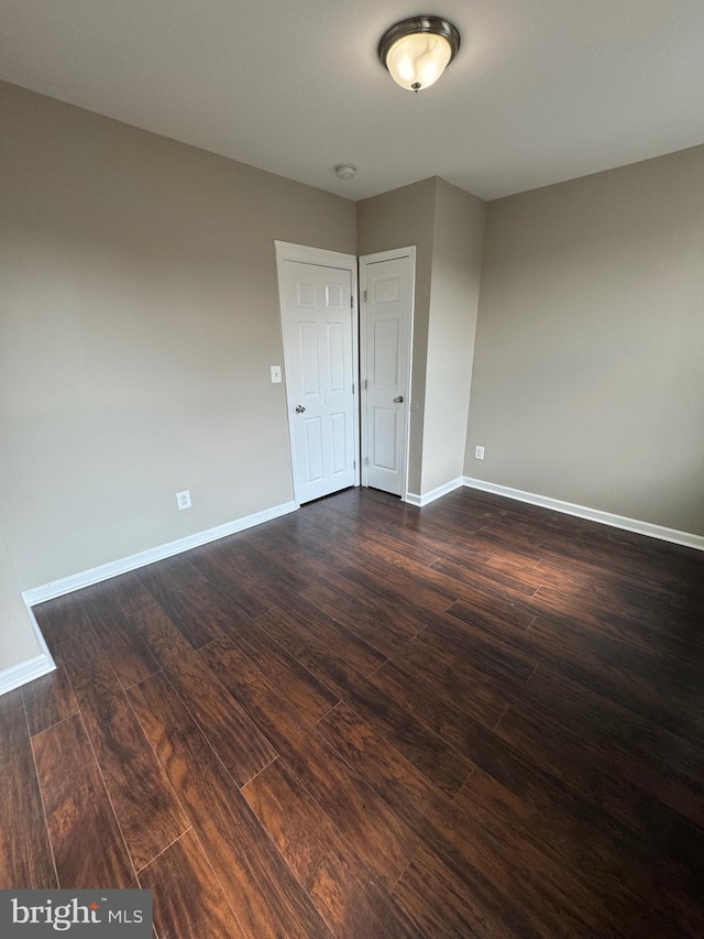 empty room with dark hardwood / wood-style flooring