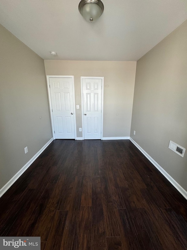 unfurnished bedroom featuring dark hardwood / wood-style floors